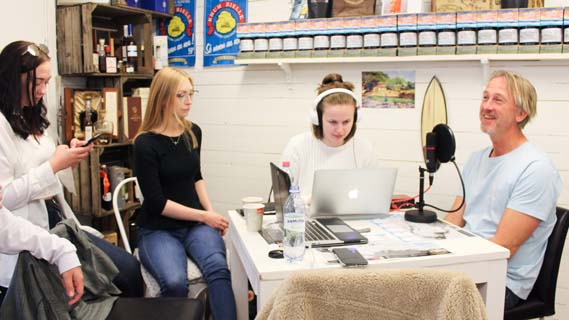 Fyra personer sitter vid ett bord och spelar in en podcast.